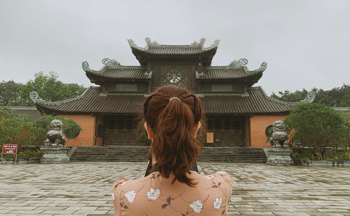 Ragazza di spalle osserva un tempio orientale