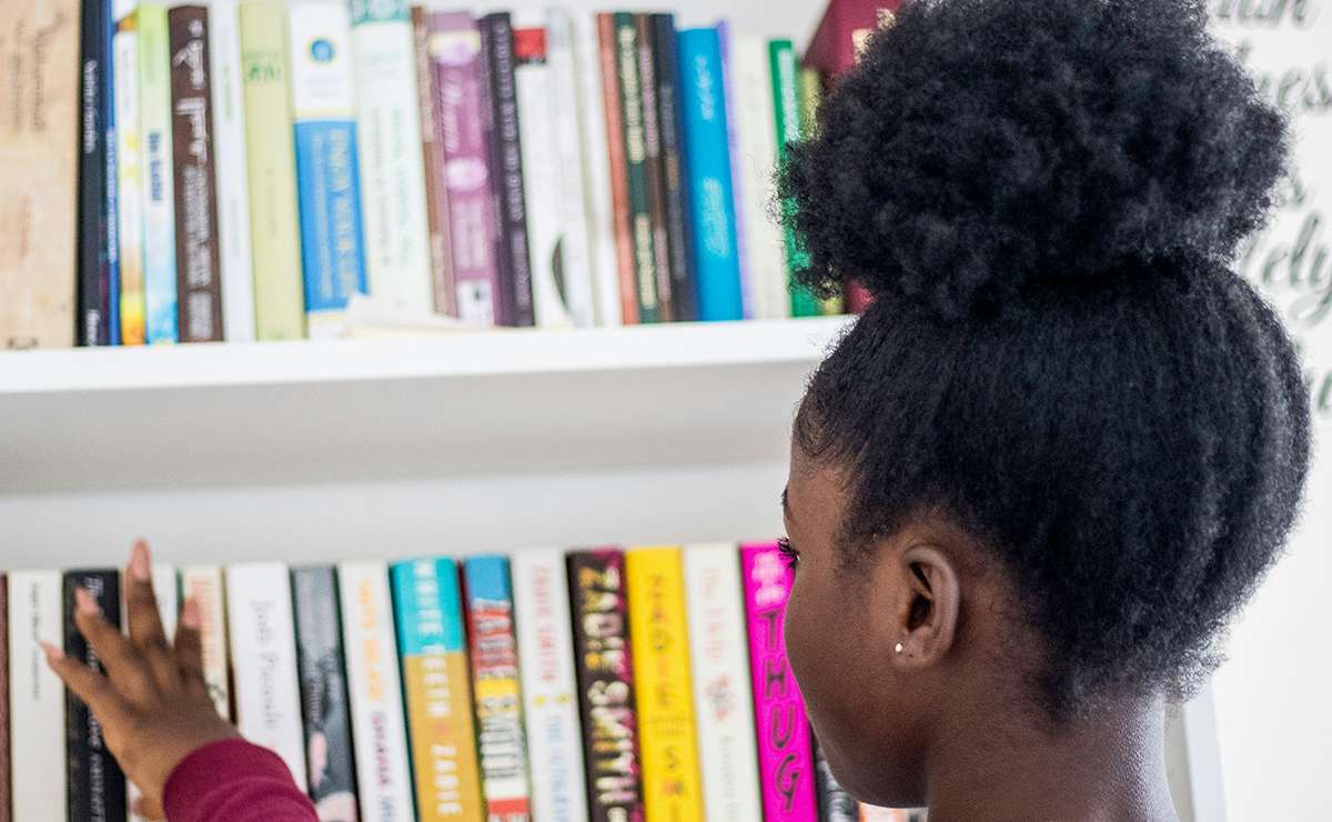 Ragazza che riordina libri nella libreria