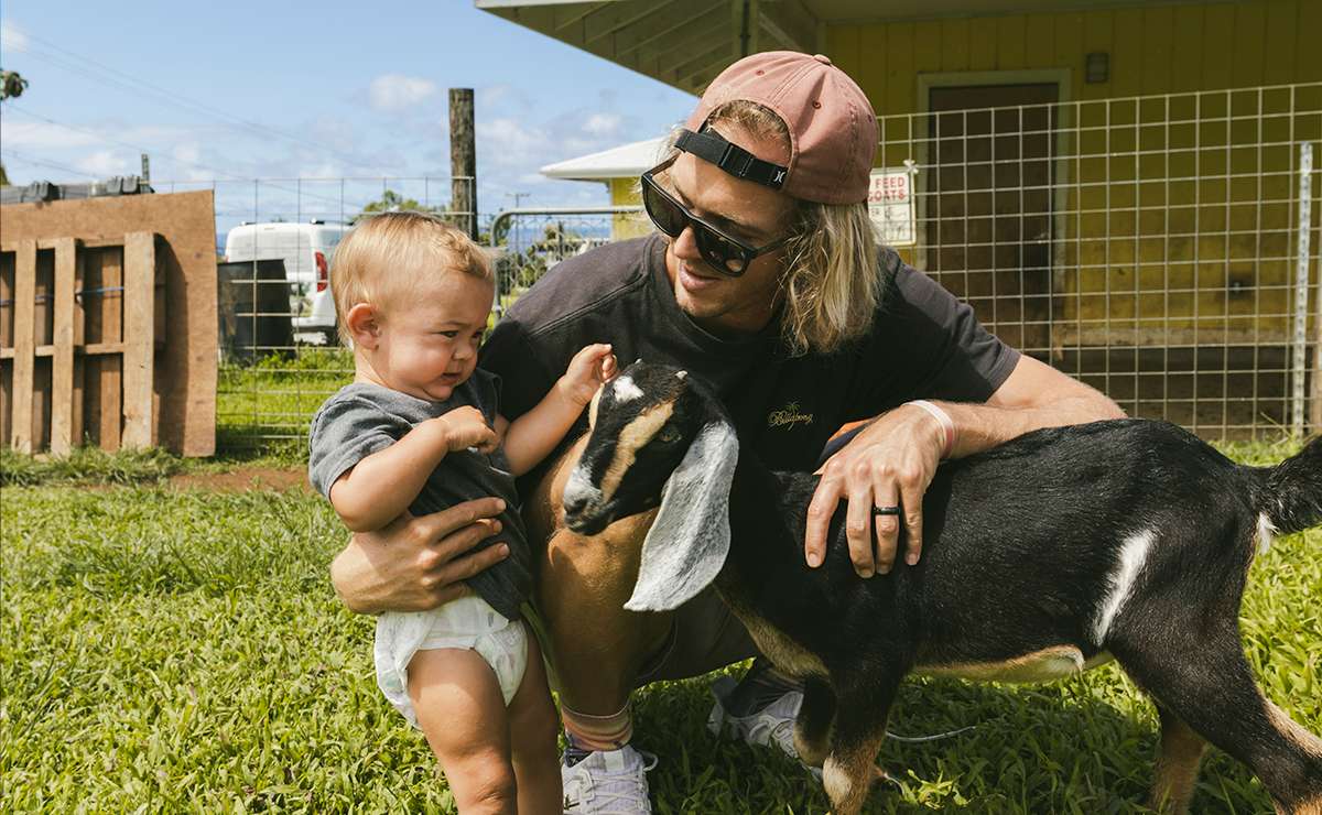 Ragazzo fa toccare una capra a un bambino