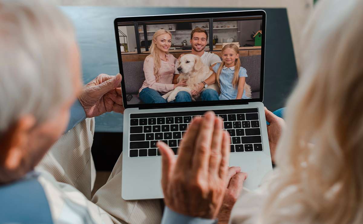 Nonni che fanno una videochiamata con figli e nipote tramite laptop, simbolo del legame tra generazioni anche a distanza