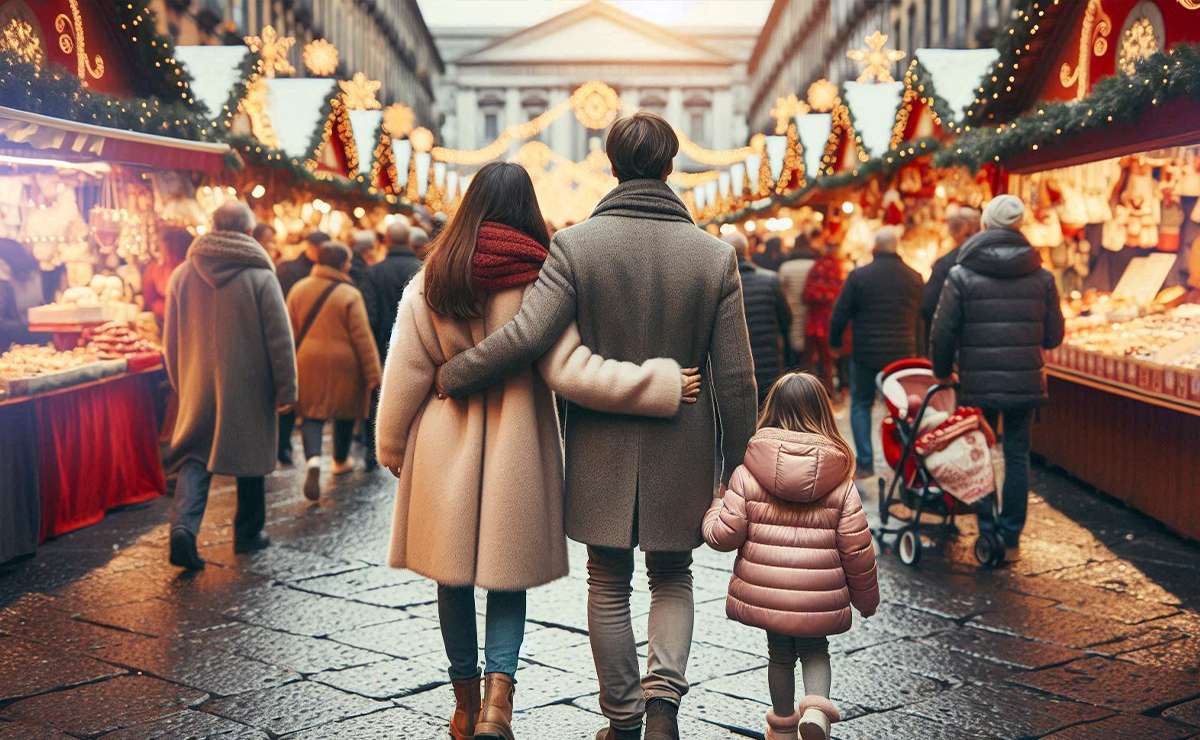 famiglia di spalle passeggia per i mercatini di Natale