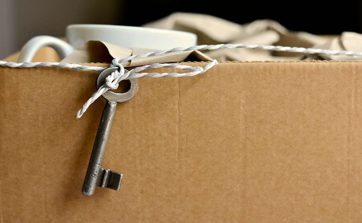 scatola di cartone con dentro abiti e una chiave 