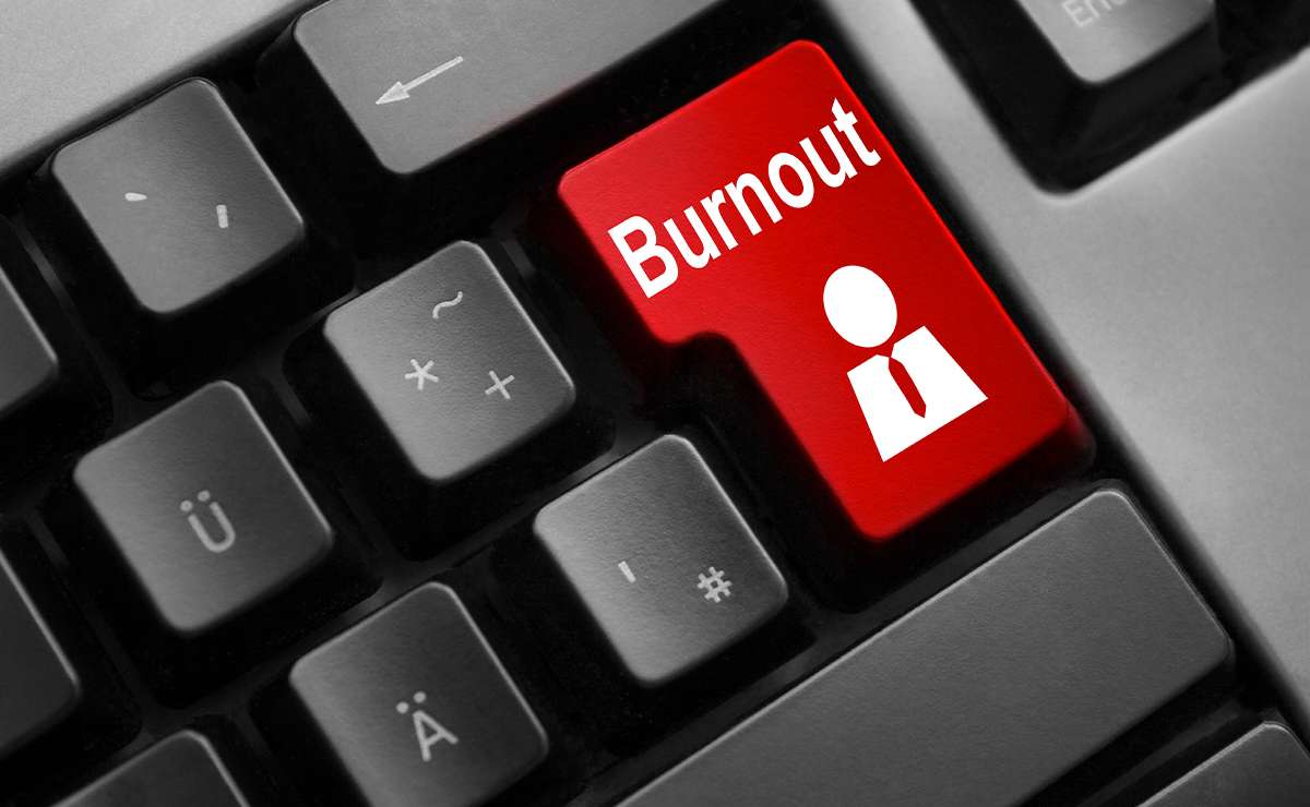 asto rosso con la scritta "Burnout" su una tastiera nera, simbolo di stress lavorativo e sovraccarico professionale.