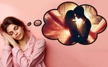 Donna che dorme con espressione serena, indossando un pigiama rosa, mentre sogna un momento di intimità rappresentato in una nuvoletta di pensiero. Nell'immagine onirica, una coppia si abbraccia in un ambiente avvolto da veli leggeri e luci calde dorate, evocando passione e connessione emotiva in un'atmosfera romantica e sognante.