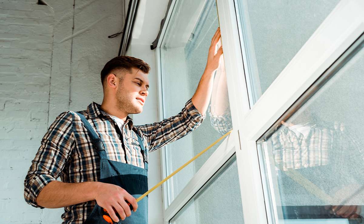 Professionista che misura un infisso su misura per garantire una perfetta installazione e personalizzazione.