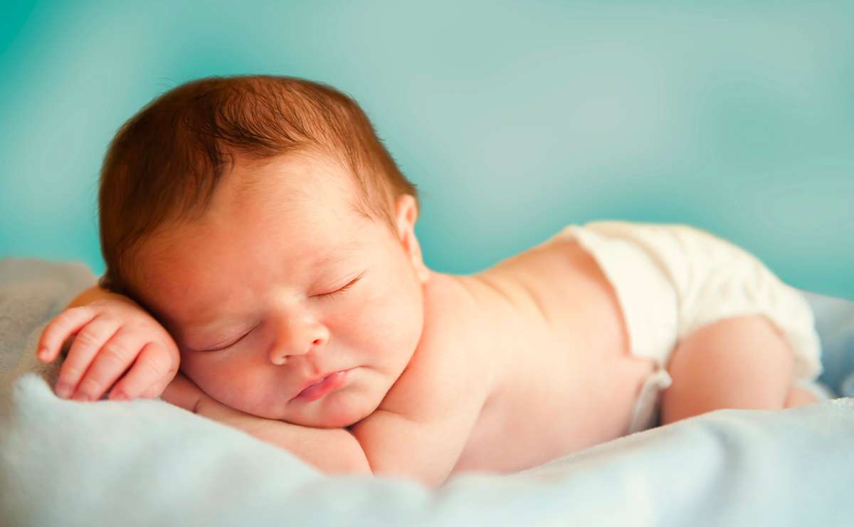Bambino neonato che dorme sereno su una coperta azzurra