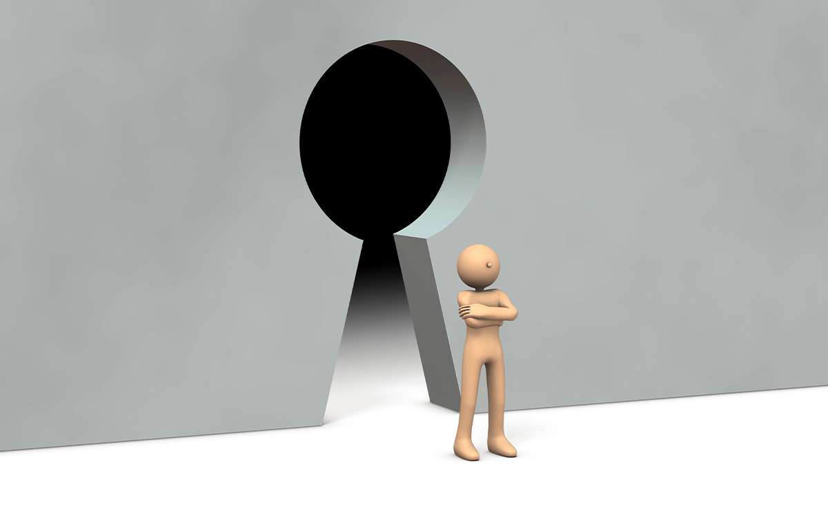 Figura umana stilizzata che blocca l’ingresso di una grande serratura, simbolo visivo del gatekeeping lavorativo e delle dinamiche di esclusione sul lavoro.