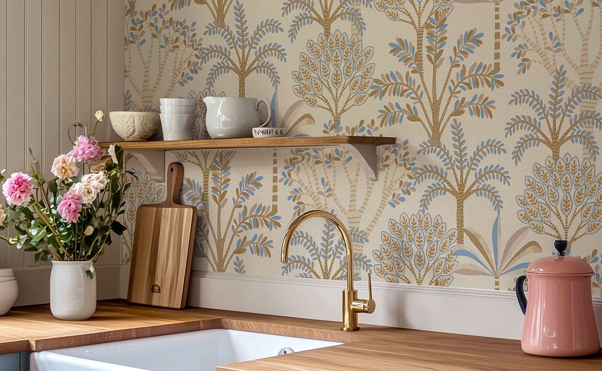 Cucina con carta da parati decorativa stile retrò a motivi botanici, piano in legno, rubinetto dorato, mensola con ceramiche bianche e mazzo di fiori freschi.