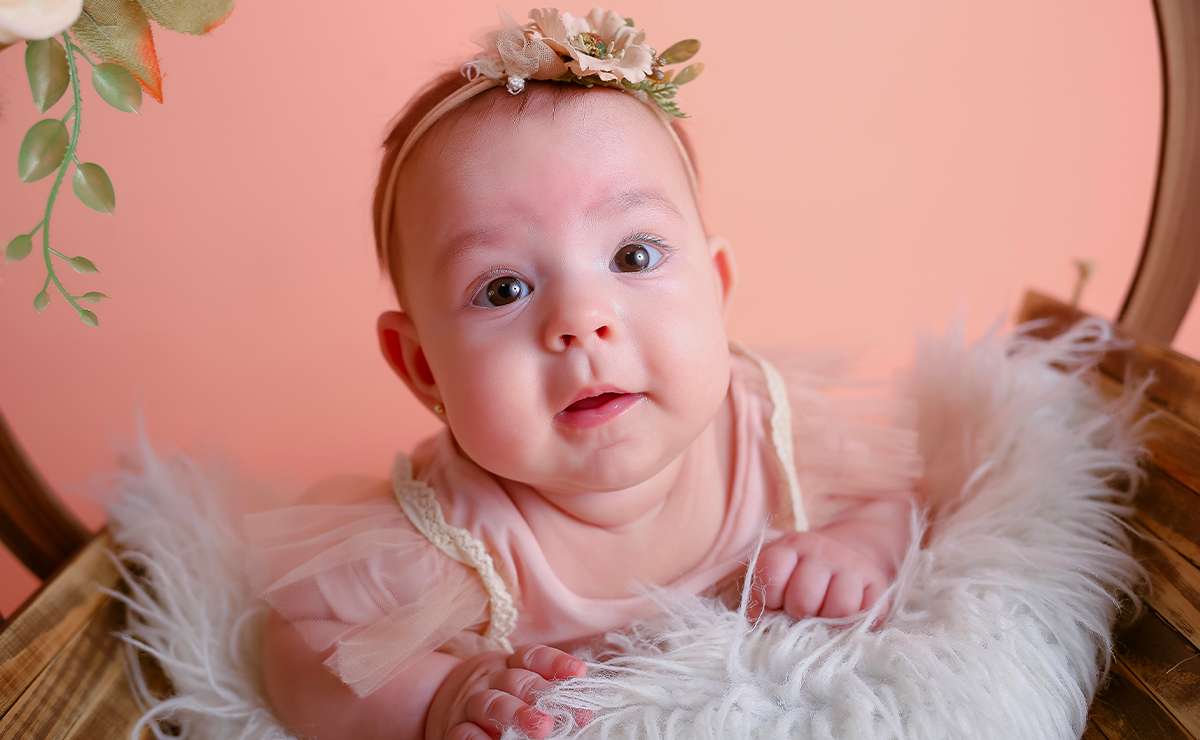 Bambina con vestito rosa e cerchietto floreale, simbolo di dolcezza e ispirazione per scegliere un nome femminile italiano con la lettera I