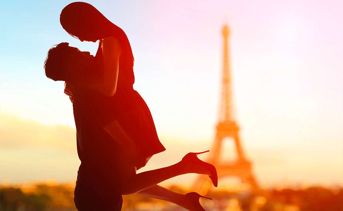 Coppia romantica al tramonto davanti alla Torre Eiffel a Parigi