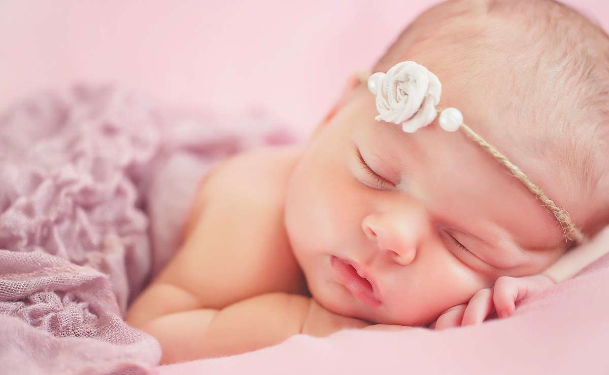Neonato che dorme con fascia floreale