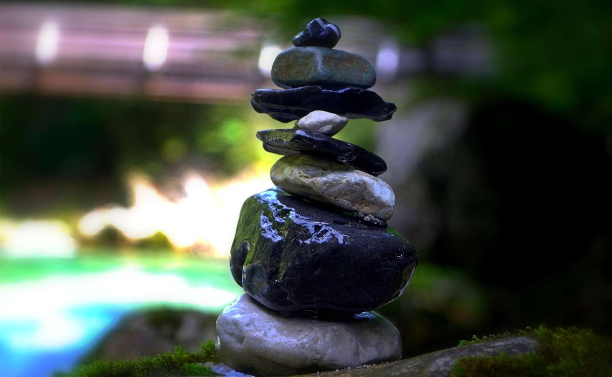 Pietre impilate in equilibrio su sfondo naturale