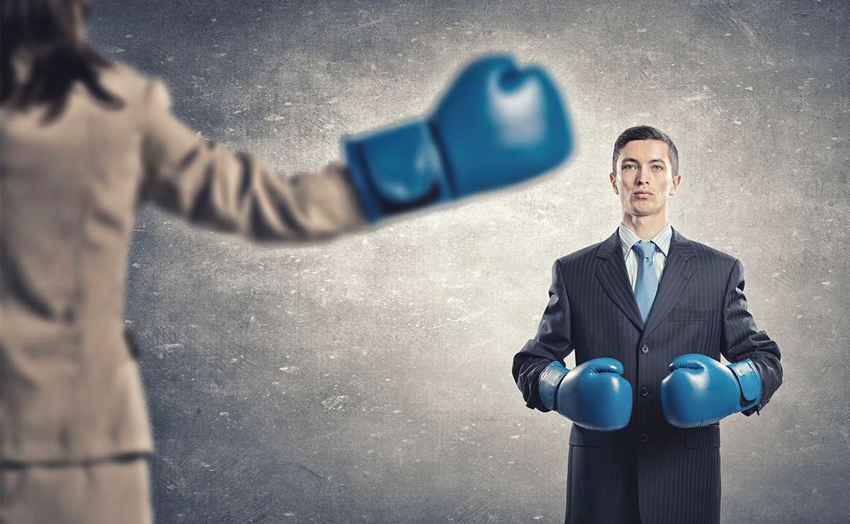 Due colleghi in abiti da lavoro con guantoni da boxe blu si fronteggiano