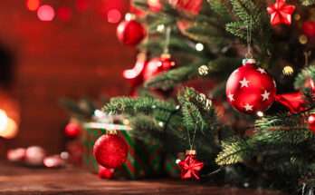 Decorazioni natalizie rosse e oro su un albero di Natale illuminato