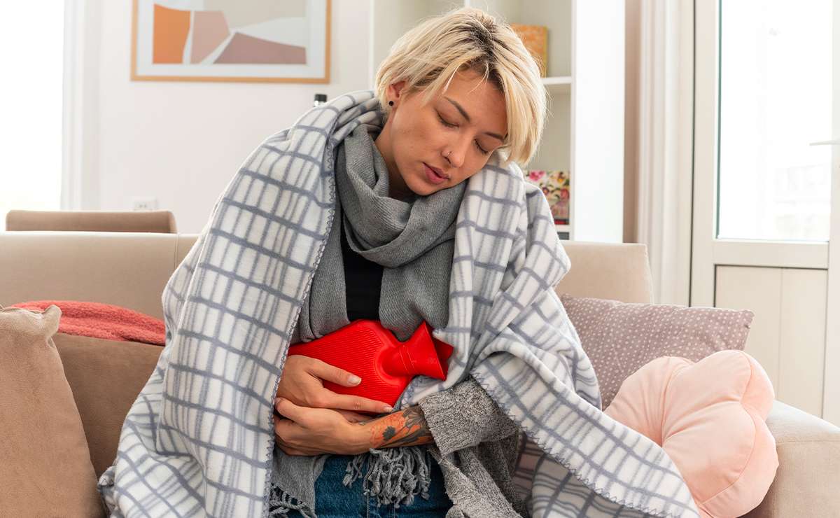 Donna seduta sul divano con influenza intestinale