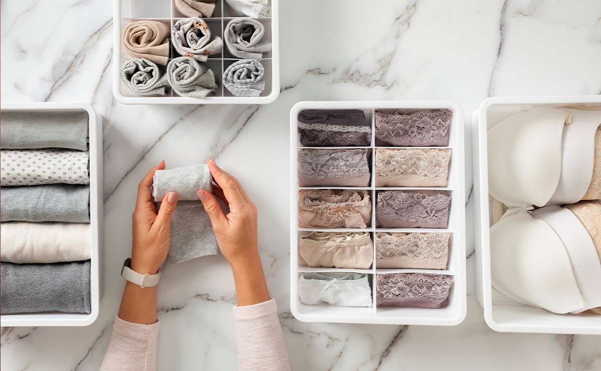 Mani che piegano un capo di abbigliamento mentre sistemano biancheria intima