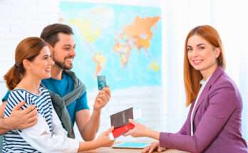 Coppia seduta in agenzia viaggi mentre consegna passaporti e carta di credito a una consulente