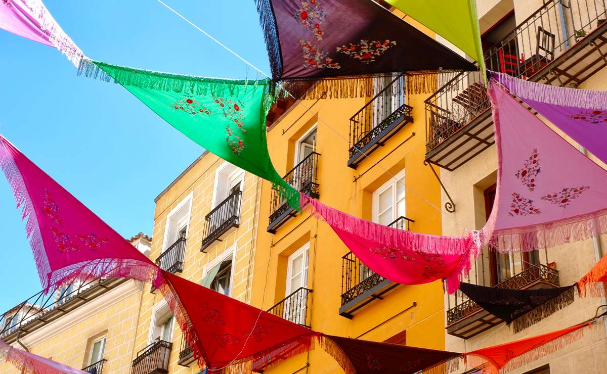 Teli colorati appesi tra i palazzi del centro di Madrid durante una festa di quartiere