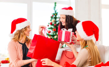 re donne con cappelli di Babbo Natale si scambiano regali