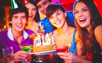 Ragazzi che festeggiano un diciottesimo compleanno con torta accesa da candeline