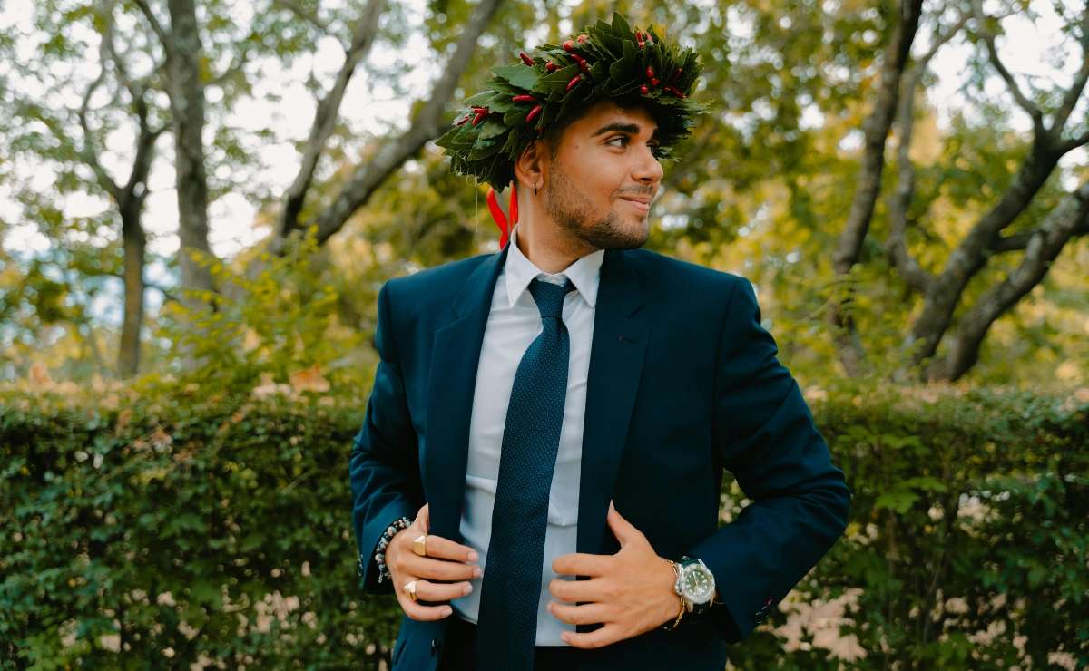 Giovane laureato con corona d’alloro e abito elegante