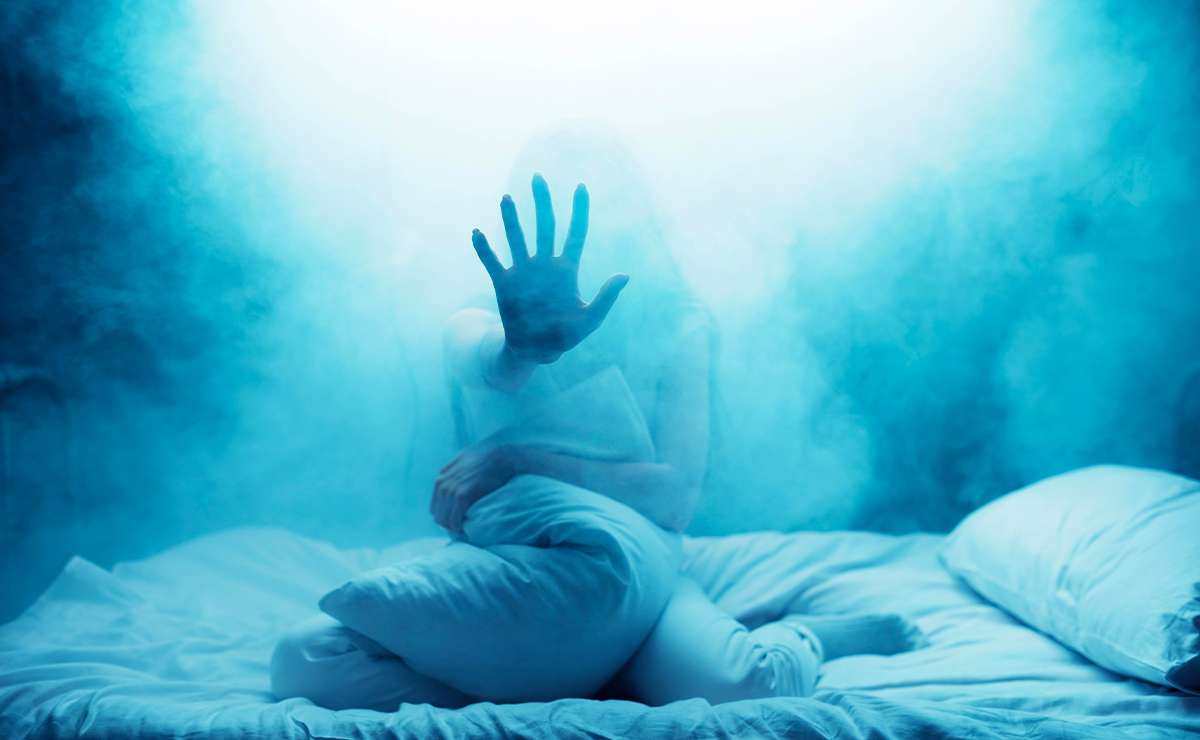 Donna seduta sul letto avvolta nella nebbia