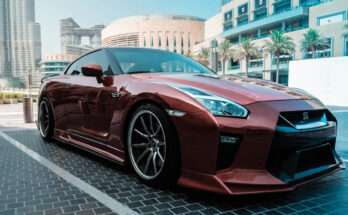 Auto sportiva Nissan GT-R color rosso metallizzato parcheggiata in una zona moderna di Abu Dhabi