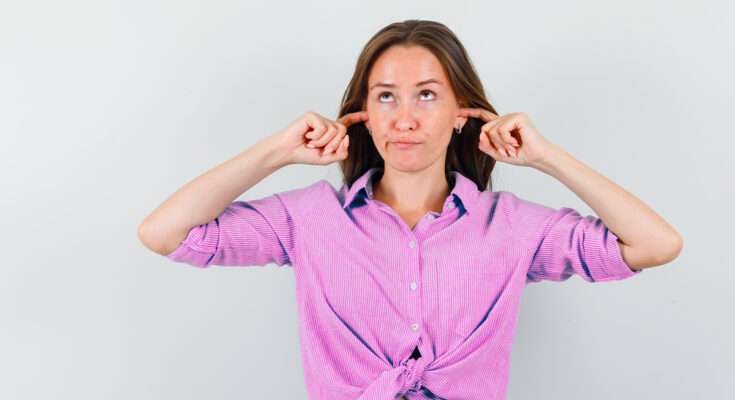 persona che si tocca le orecchie per un fischio improvviso