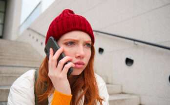 ragazza parla al telefono seduta su scalinata