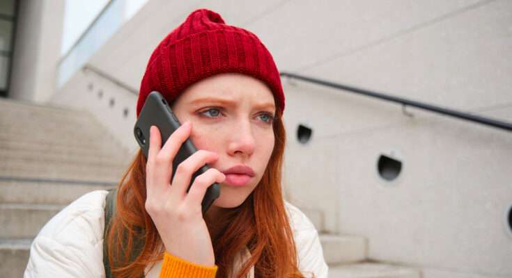 ragazza parla al telefono seduta su scalinata