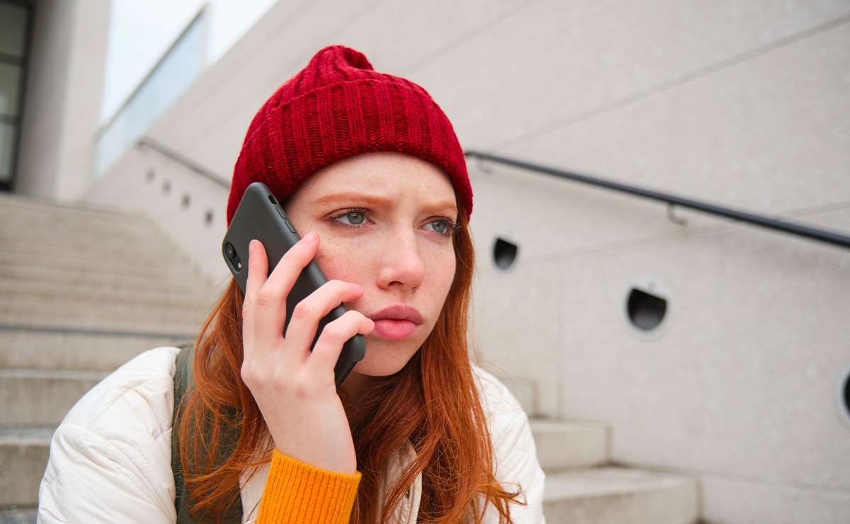 ragazza parla al telefono seduta su scalinata