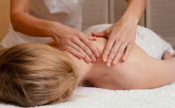 Massaggio miofasciale alla schiena eseguito da un operatore su una donna distesa sul lettino