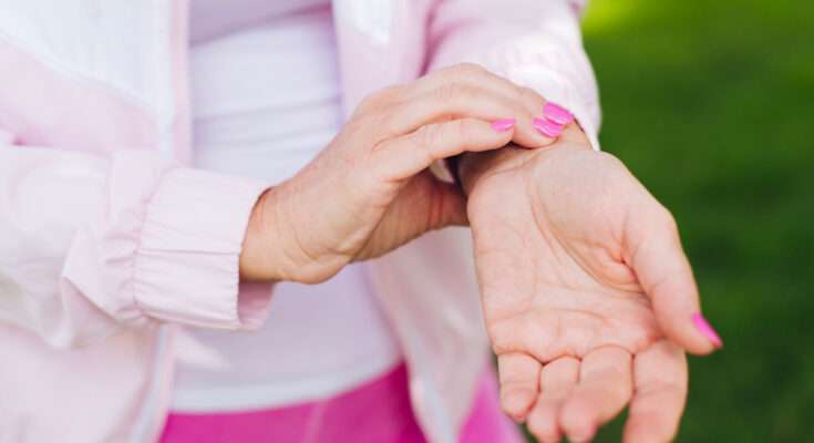 persona che si gratta il palmo della mano per formicolio